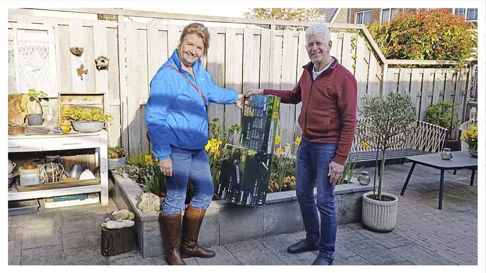 Fractievoorzitter Judith Keessen van FlorAalsmeer overhandigt de nieuwe kettingzaag aan Dick Maarsen van Stichting Behoud Seringenpark Aalsmeer