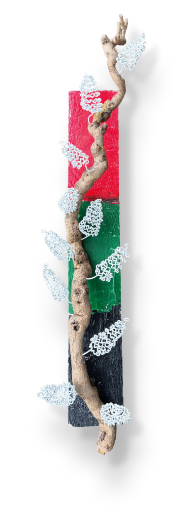 Kunstobject van draadartiest Frans de Boer uit Aalsmeer. plank geschilderd in de kleuren van de Aalsmeerse vlag (rood, groen en zwart) met daarop een seringentak met seringen die in 1 lijn gemaakt zijn van draadstaal.