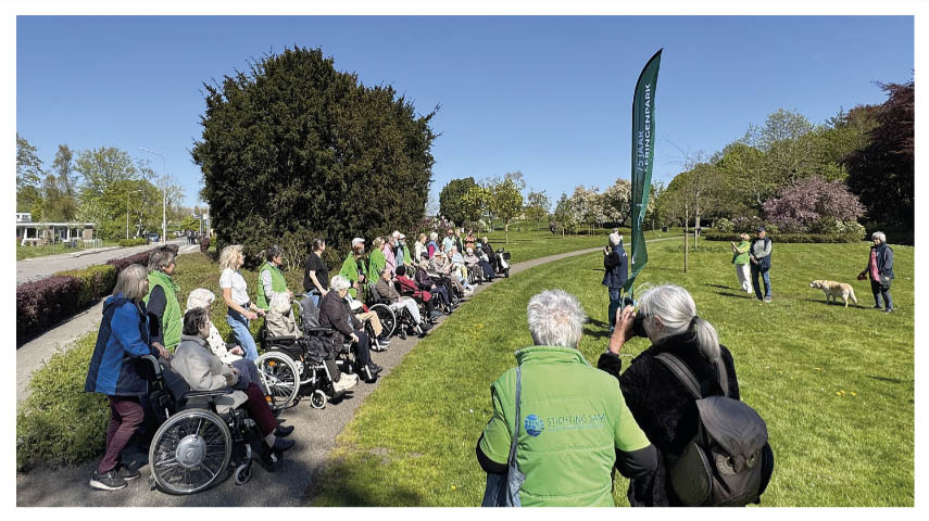 De vrijwilligers en deelnemers van Stichting Sam verzamelen zich aan het begin van het park