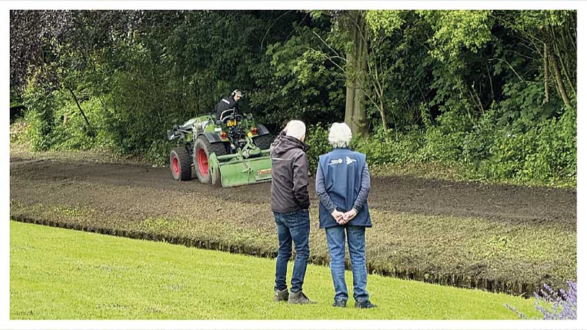 Magda en Dick kijken hoe het talud in het Seringenpark opgeschoond wordt